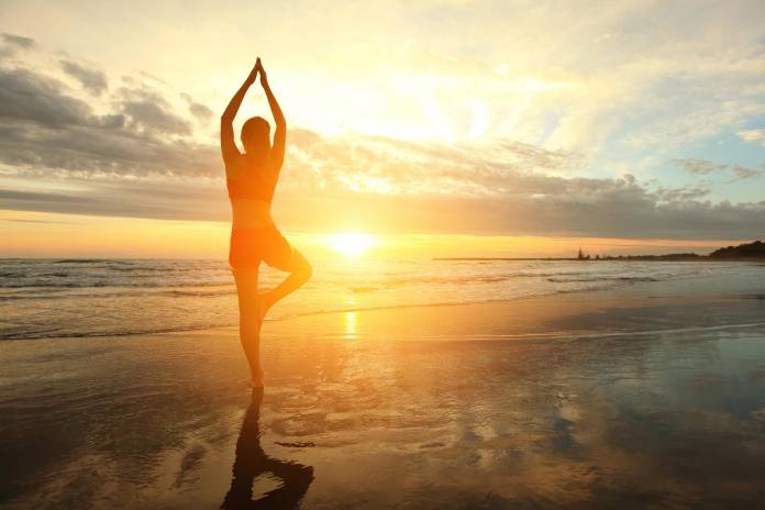 Yoga am Strand bei Sonnenuntergang